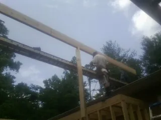 Carpenter setting a ridge beam over a new addition frame — Ice Dam Removal by Roofing Brothers in Panora