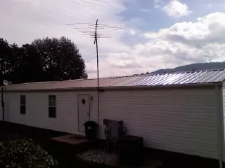 New metal roof on a single wide mobile home with a TV antenna in Panora
